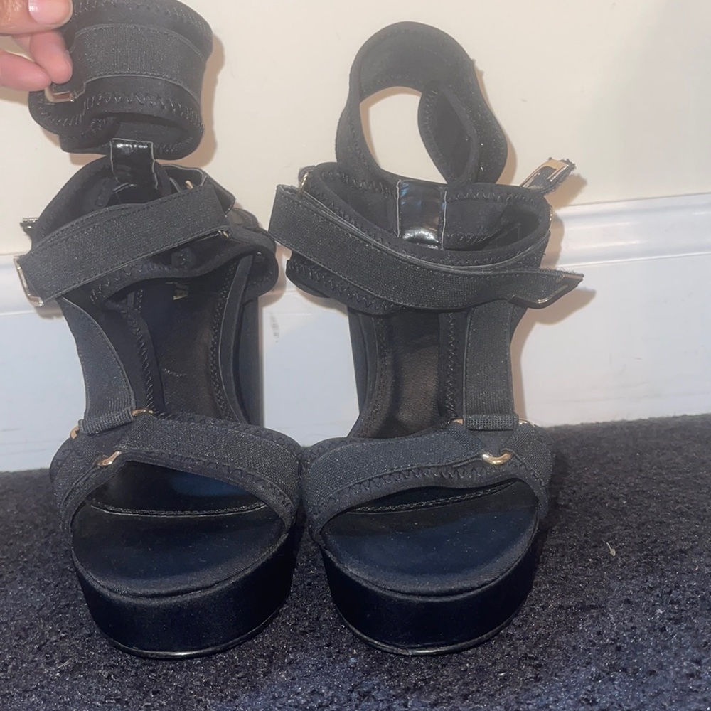 Strappy sandal with thick black straps that fasten with Velcro.